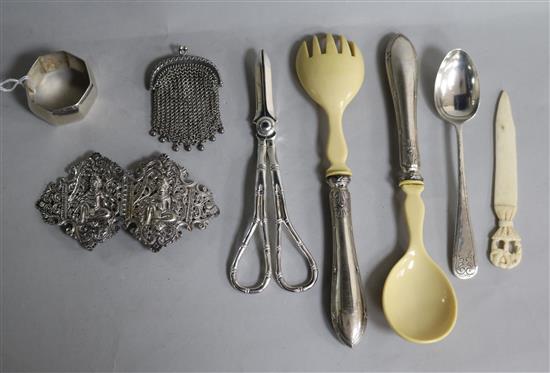 A small group of silver and white metal items including salad servers, buckle, purse and plated grape shears.